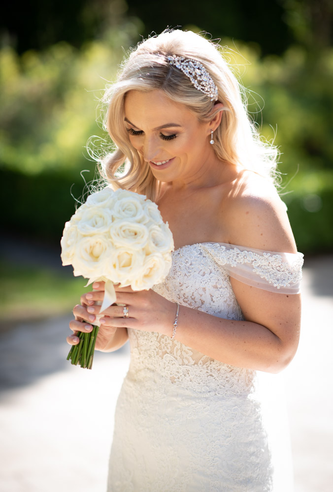 Bride smelling her white rose wedding bouquet