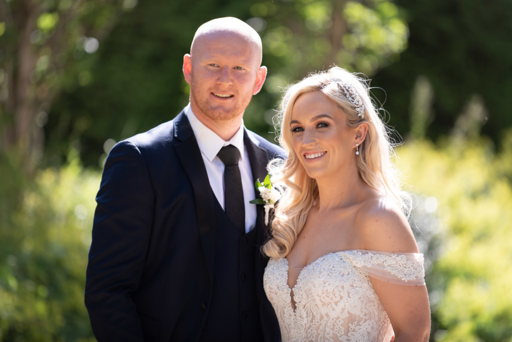 Bride and Groom smiling while standing together in the Powerscourt Hotel garden