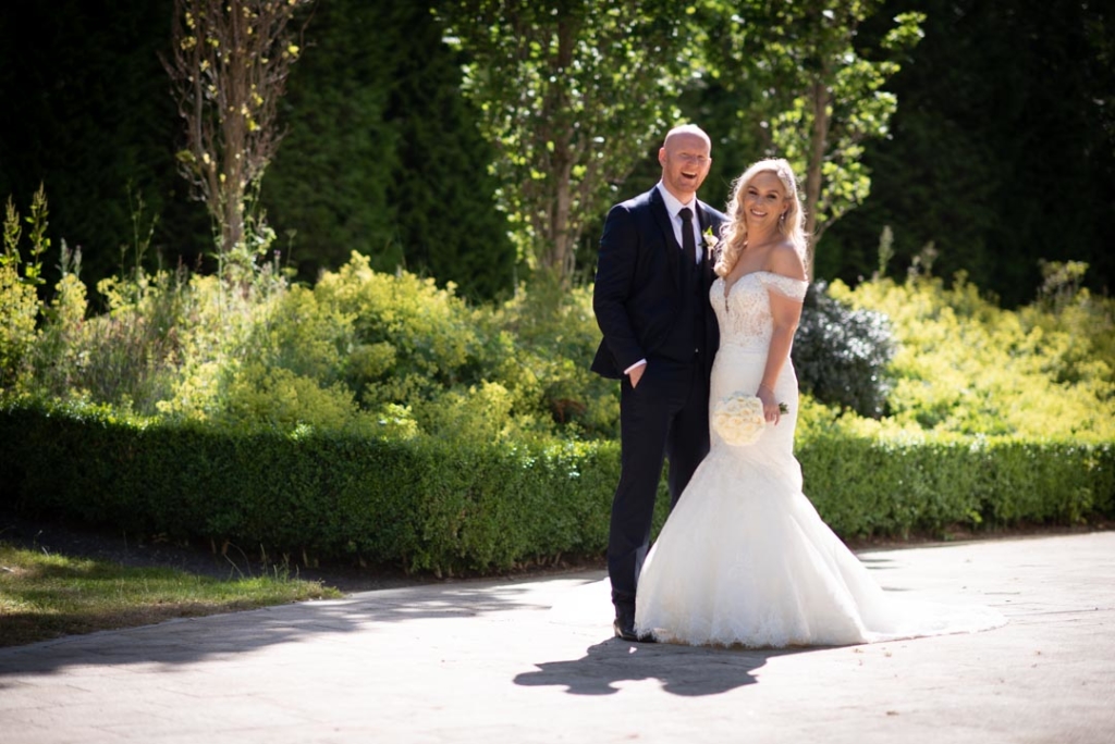 Bride and Groom standing and laughing in the garden for their Powerscourt hotel wedding