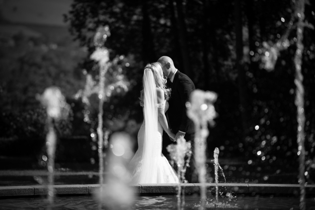 Bride and Groom kissing in front of the water fountain