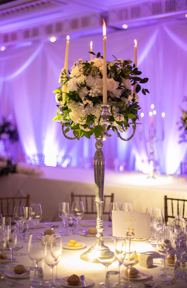 Silver candelabra with white flowers in the centre of the table