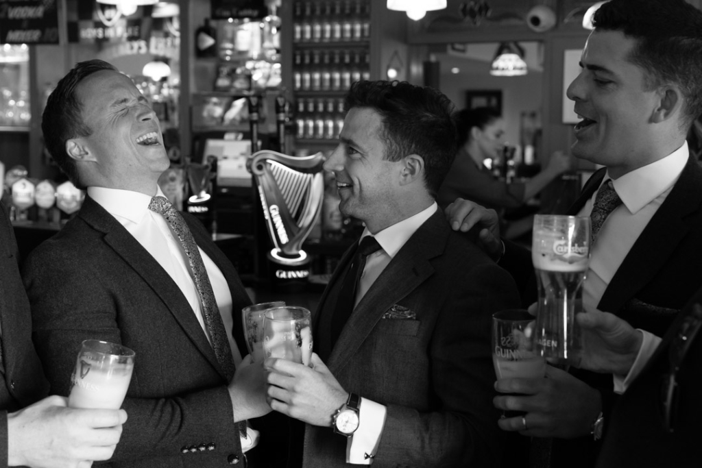 Groom and groomsmen laughing in the pub