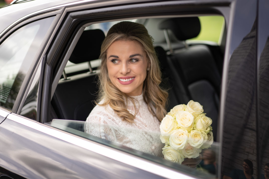 Bride in the back of the wedding car at the Church