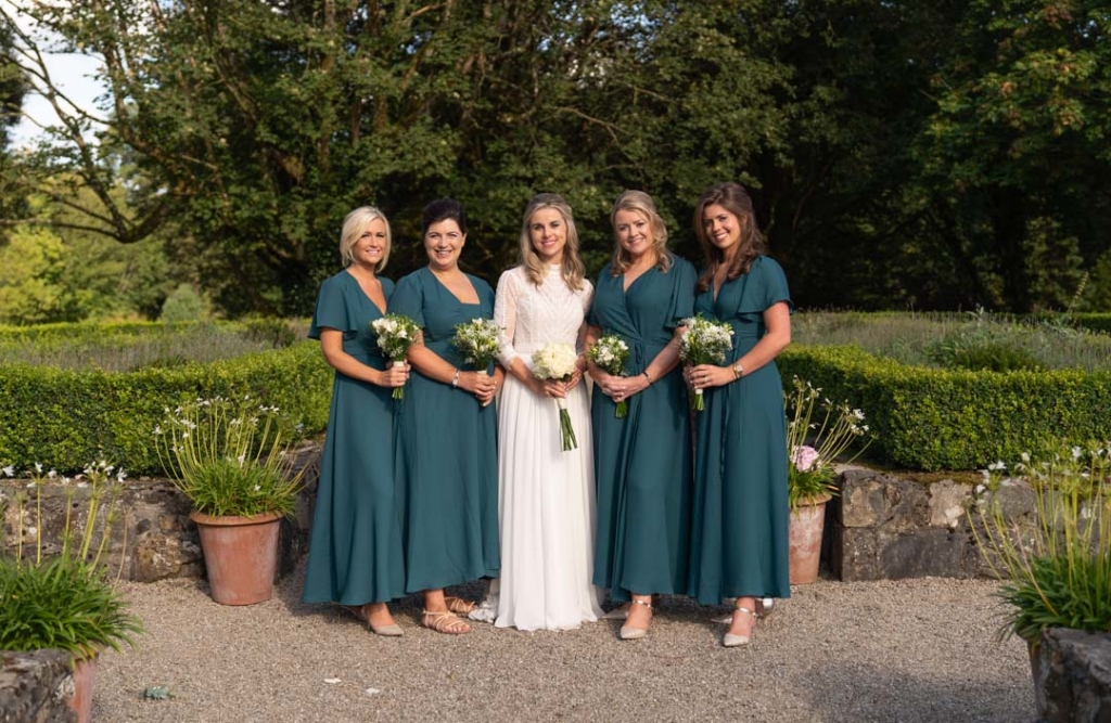 Bride in white and her bridesmaids in green dresses holding their flower bouquets at Virginia Park Lodge wedding