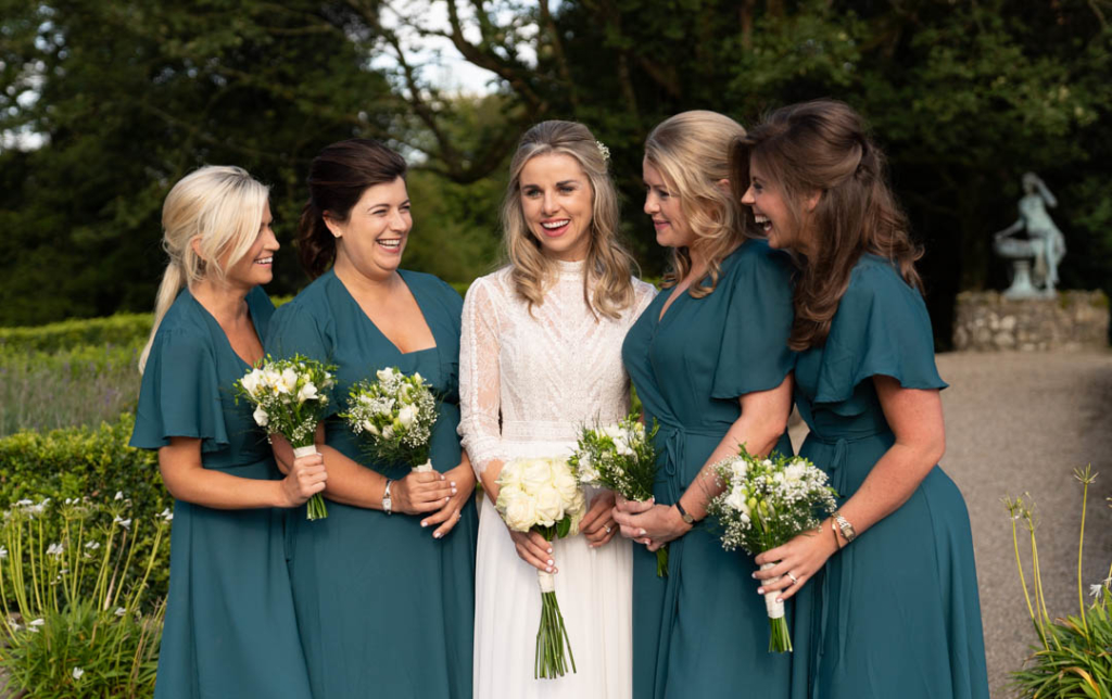Bride and her bridesmaids looking and laughing with each other