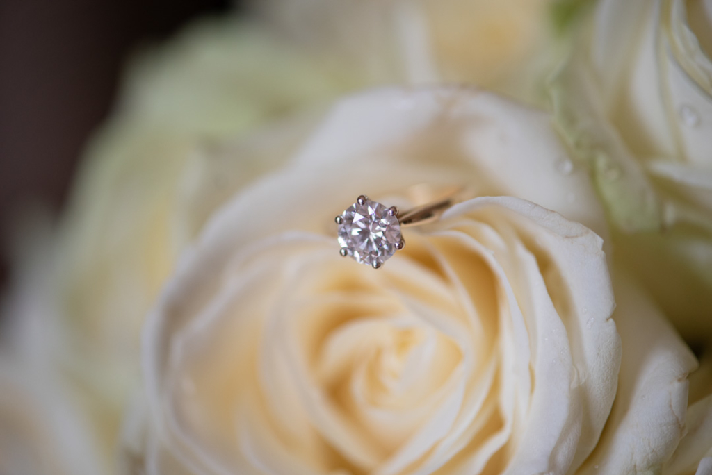 Brides diamond engagement ring on white rose