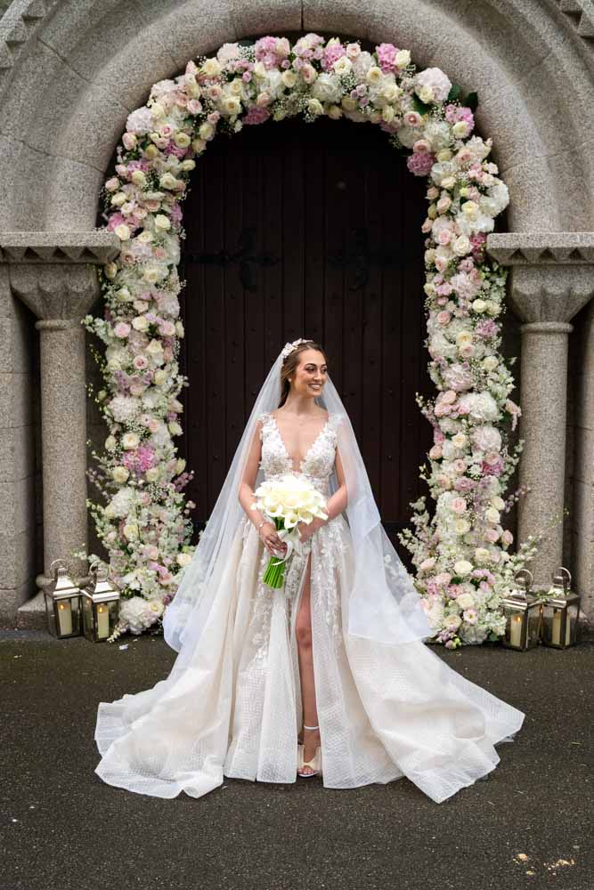 Bride at the Church door with a flower arch around the door
